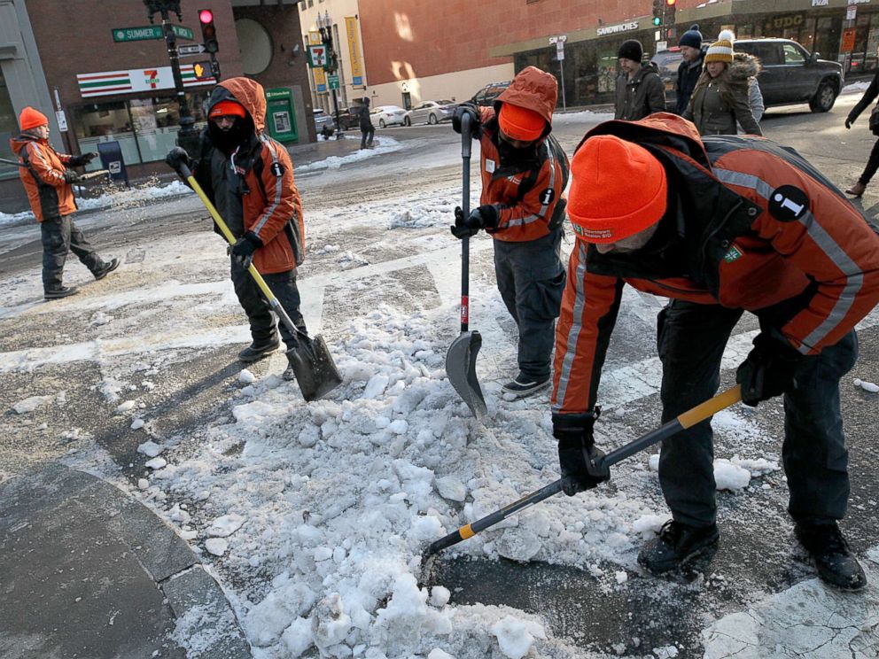 PHOTO: Workers shovel ice and snow from the intersection of Arch and Summer streets in downtown Boston, Dec. 26, 2017.