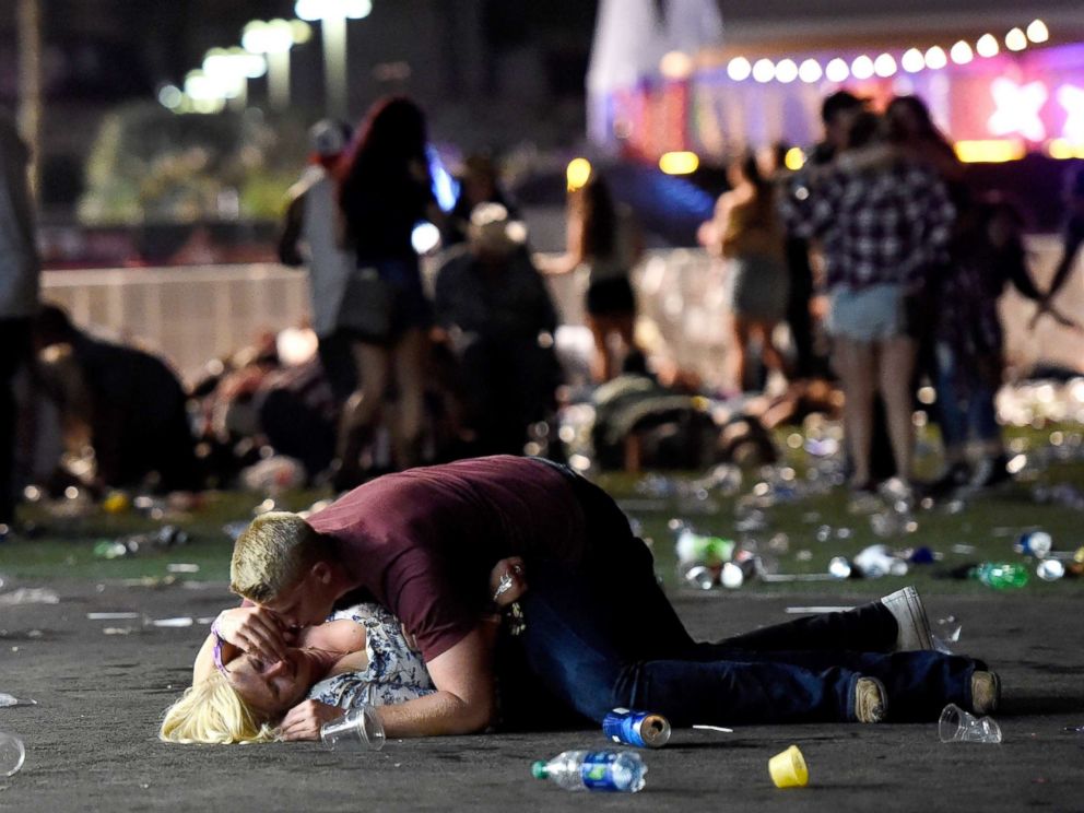 PHOTO: A man lays on top of a woman as others flee the Route 91 Harvest country music festival grounds after an active shooter was reported on Oct. 1, 2017 in Las Vegas. The woman later was seen getting up with help. 