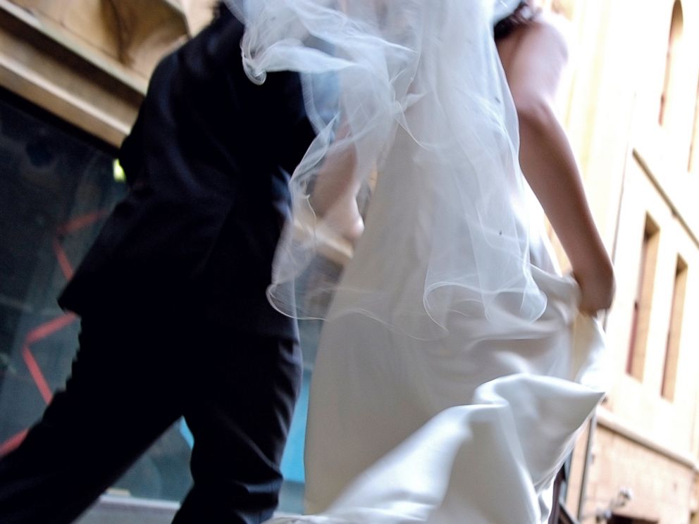 PHOTO: Bride and groom is running side by side in this stock image.
