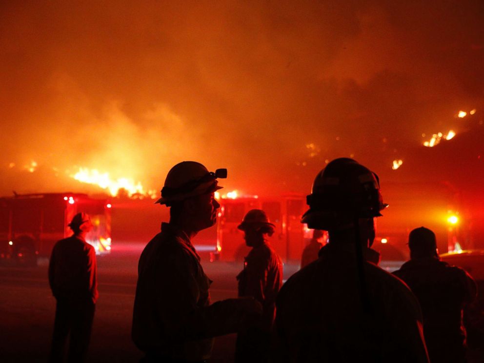 PHOTO: Firefighters gather in front of a residential area as a wildfire burns along the 101 Freeway, Dec. 5, 2017, in Ventura, Calif. 