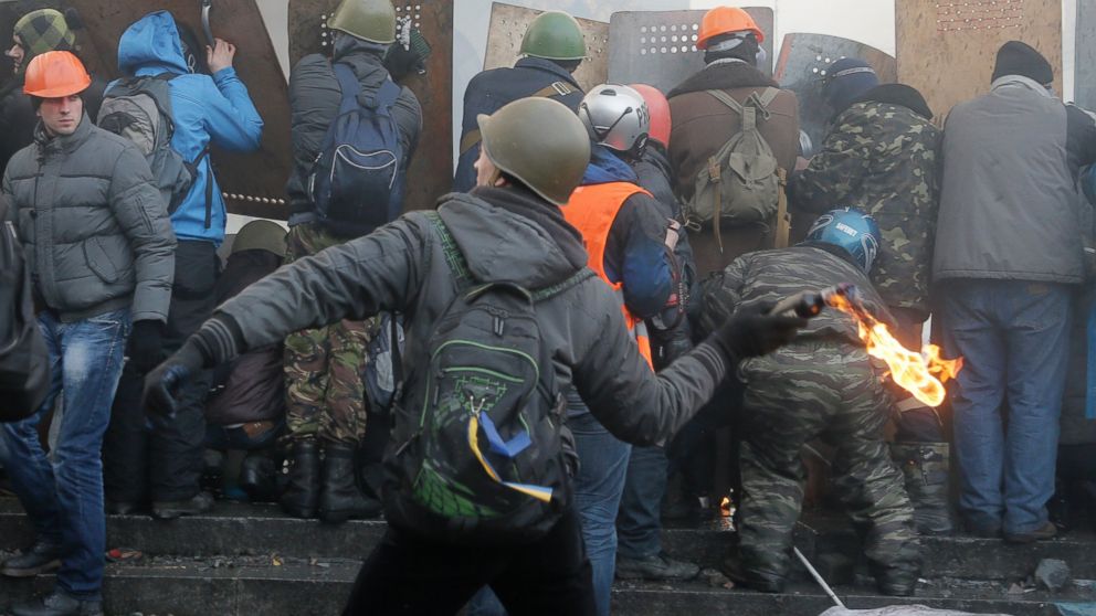 PHOTO: An anti-government protester, center, throw a Molotov cocktail during clashes with riot police in Kievs Independence Square, the epicenter of the countrys current unrest, Kiev, Ukraine, Wednesday, Feb. 19, 2014.