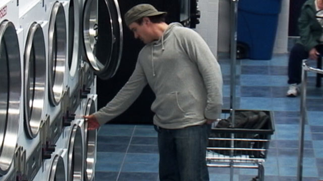 PHOTO a laundry thief who starts taking clothes from the machine the customer has been entrusted with and putting the ones he likes in a basket with all the other clothes hes taken.