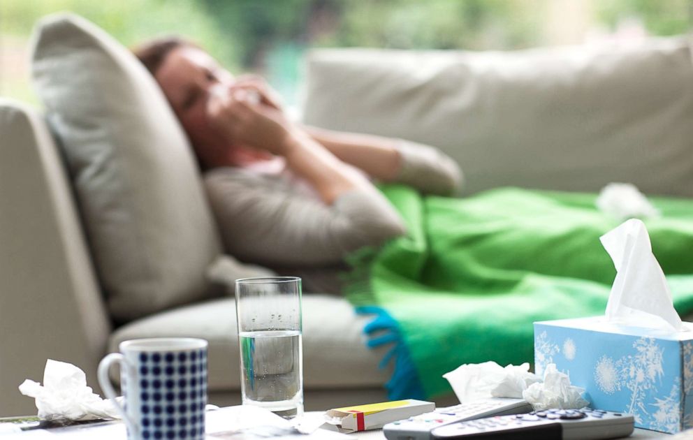 PHOTO: A sick woman lays on a couch blowing her nose in this undated stock photo.