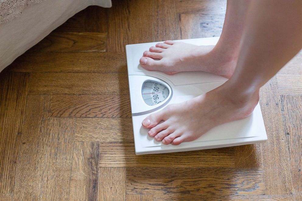 PHOTO: A woman checks here weight on a bathroom scale in this undated stock photo.