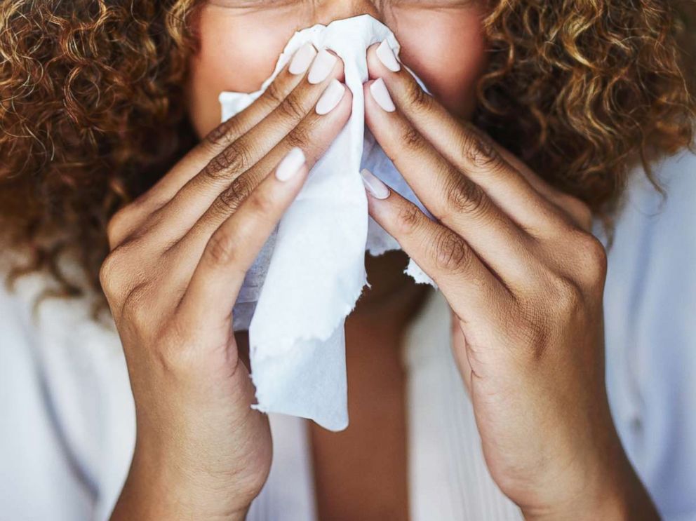 PHOTO: A woman uses a tissue to sneeze in this undated stock photo.