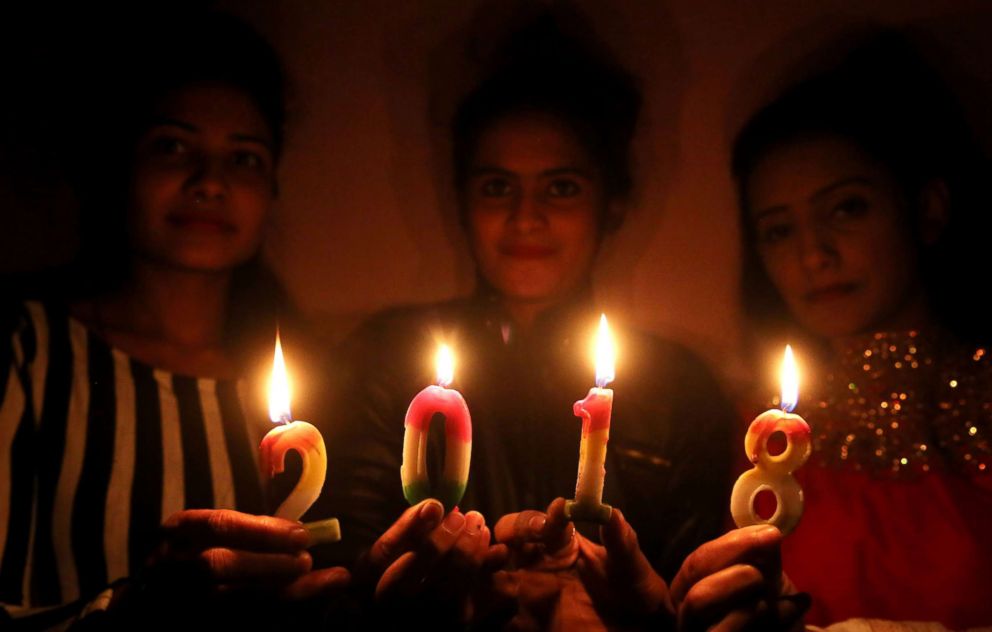 PHOTO: Indian girls pose for photographs with lighted candles during celebrations to welcome the new year in Bhopal, India, Dec. 31, 2017. 