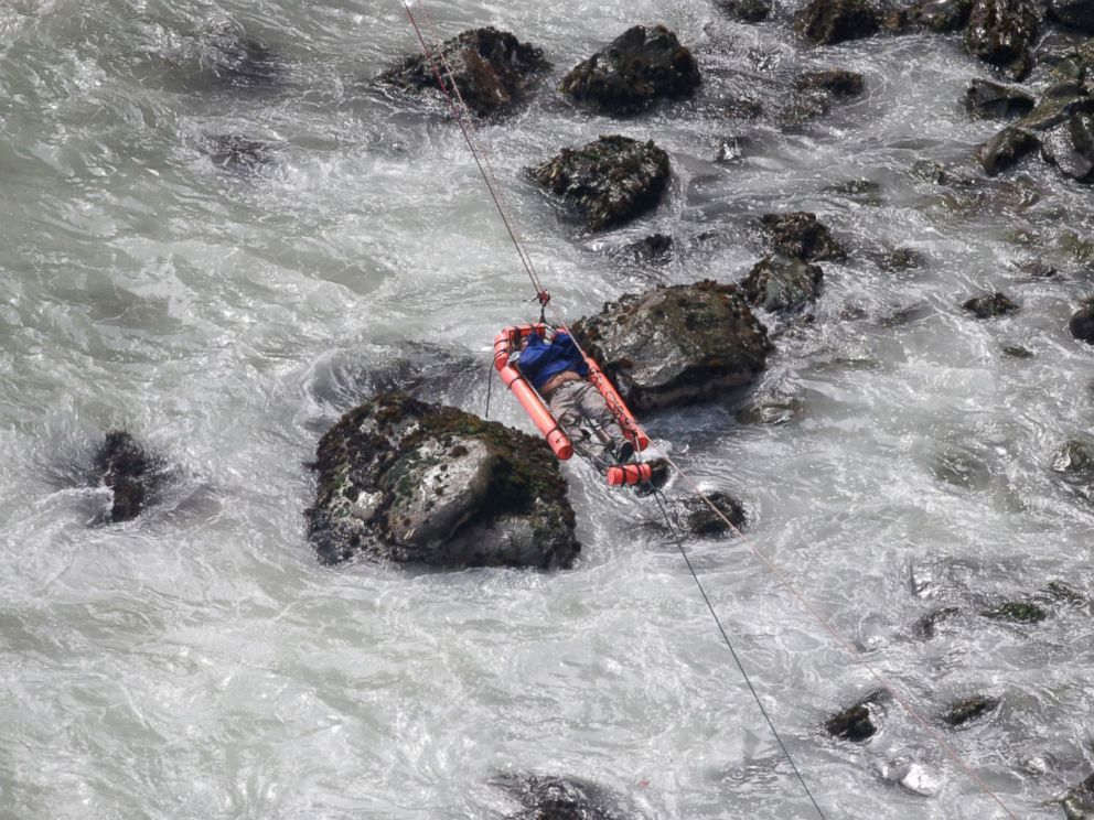 PHOTO: An injured man is transported over water from a bus that fell off a cliff after it was hit by a tractor-trailer rig, in Pasamayo, Peru, Jan. 2, 2018.